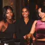 Three women smiling and posing for a photo.